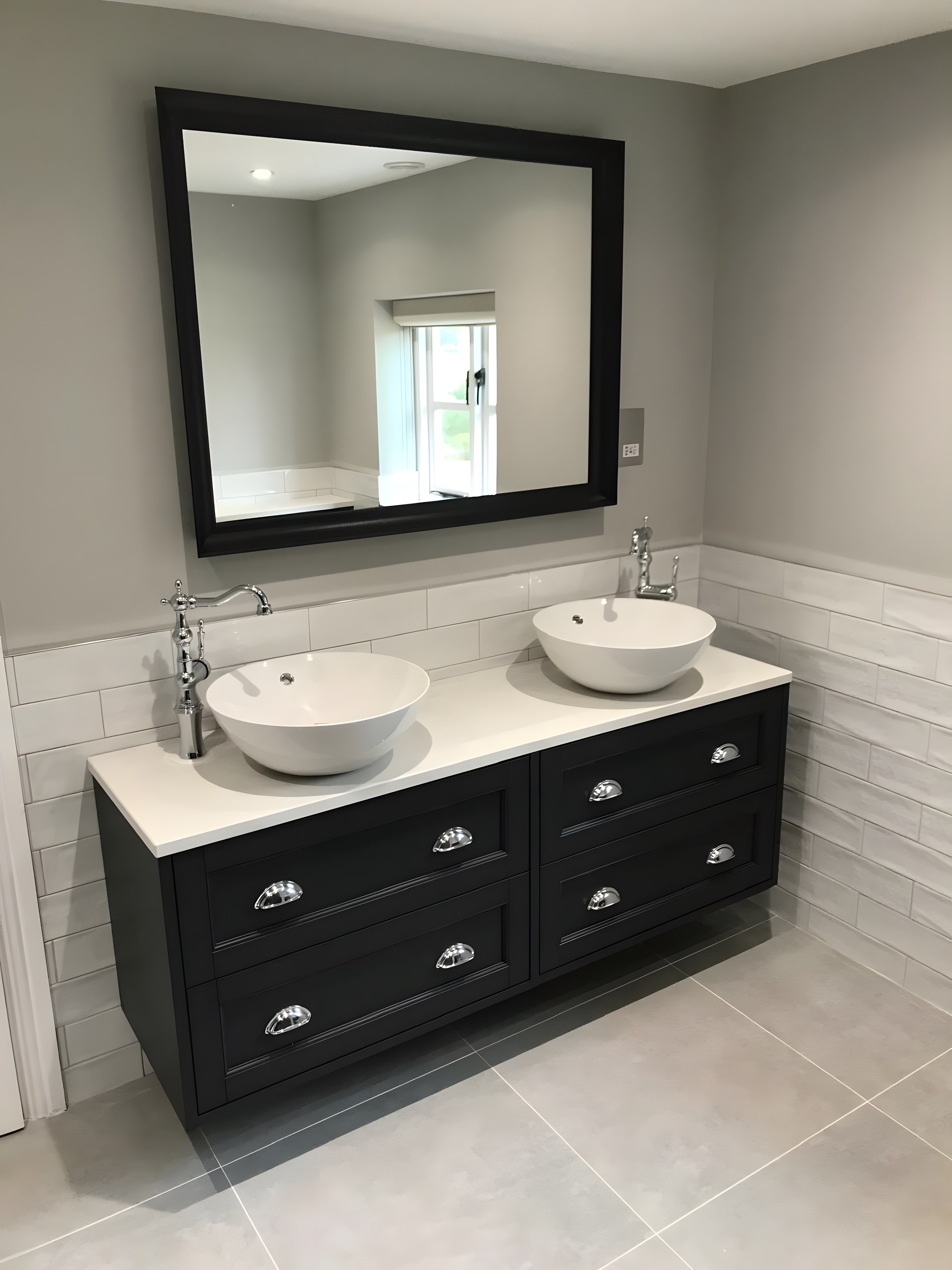 Double basins on a dark painted vanity with framed mirror