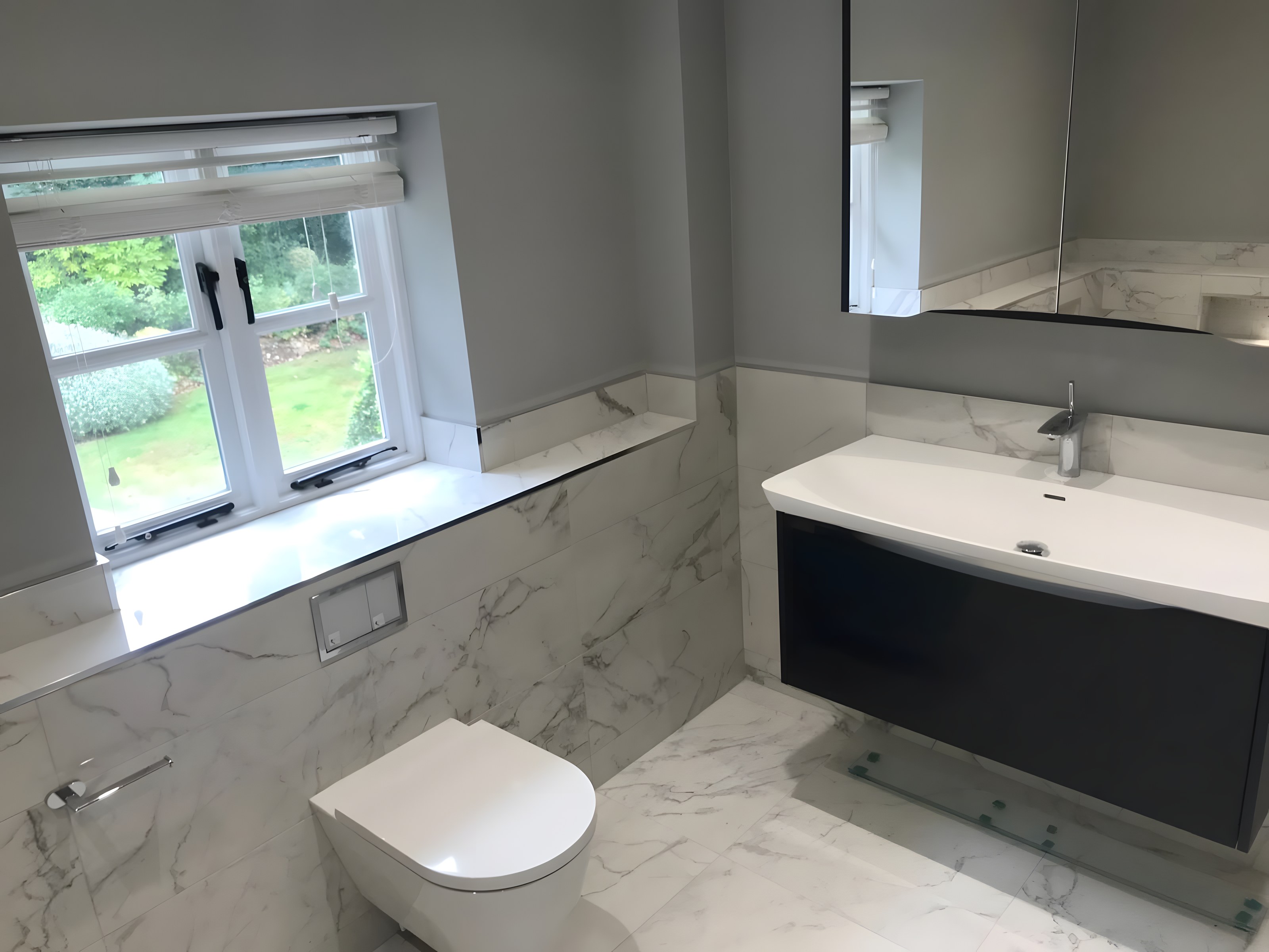 Bright marble bathroom with floating vanity, wall-hung WC and garden window